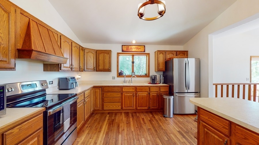 43375 Hunt Club Road Zion, IL 60099 - Photo 5 of 56 a kitchen with stainless steel appliances granite countertop a stove a sink dishwasher and a refrigerator with wooden floor