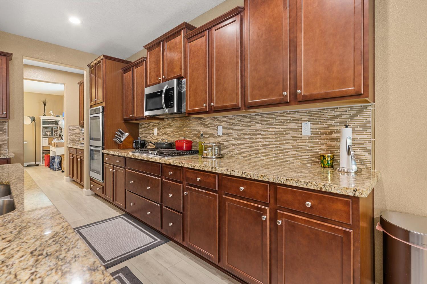 2317 Mathar Drive Manteca, CA 95337 - Photo 20 of 48 a kitchen with stainless steel appliances granite countertop wooden cabinets a sink and dishwasher