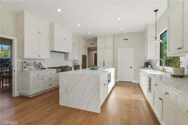 a view of a living room with a floor to ceiling window and a kitchen view