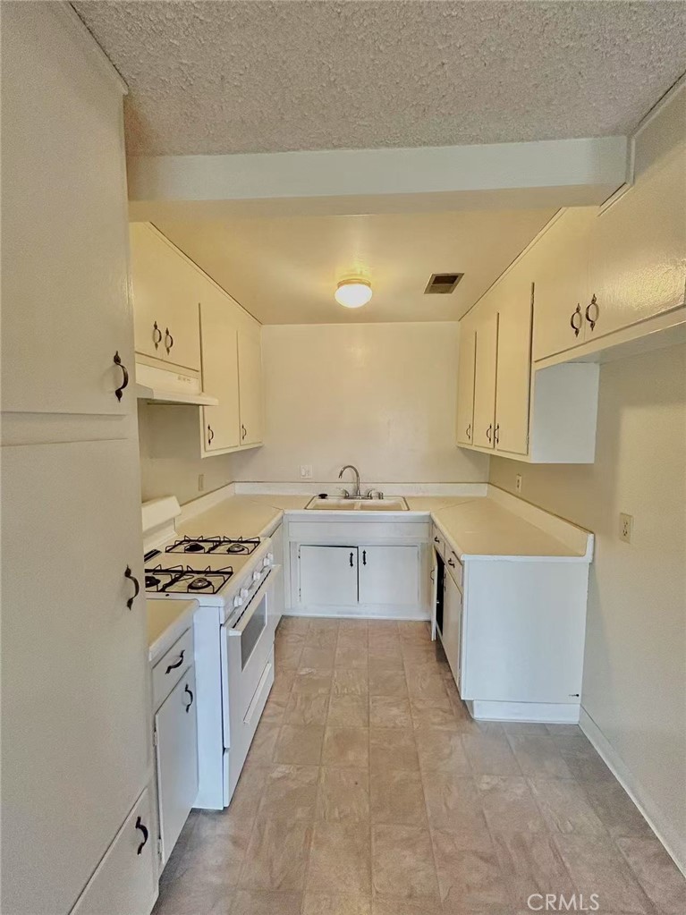 922 West Duarte Road, Unit 11 Arcadia, CA 91007 - Photo 10 of 17 a kitchen with stainless steel appliances a stove a sink and white cabinets