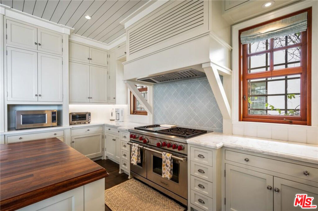 212 The Strand Manhattan Beach, CA 90266 - Photo 17 of 74 a kitchen with stainless steel appliances white cabinets and a stove top oven