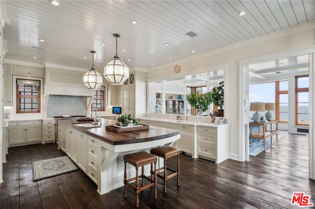212 The Strand Manhattan Beach, CA 90266 - Photo 19 of 74 a kitchen with stainless steel appliances a dining table chairs stove and cabinets