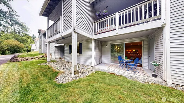 a view of a house with backyard and sitting area