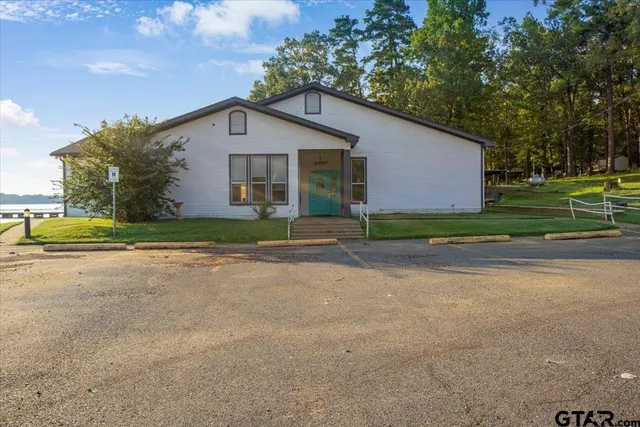 a view of a house with a yard and large tree