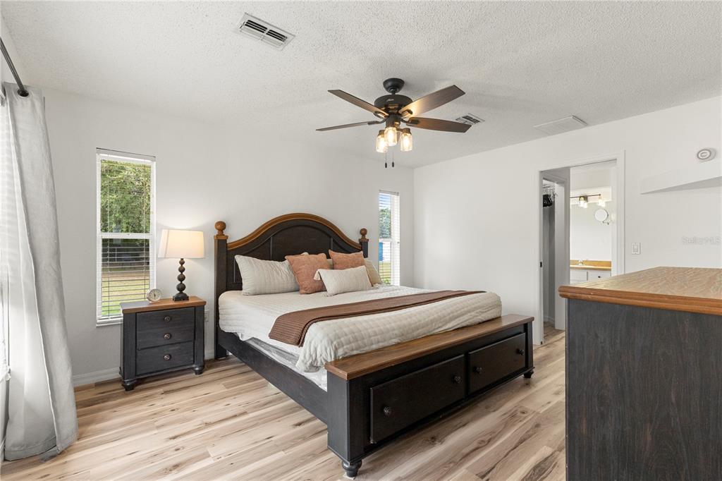 9917 Nelson Road Dade City, FL 33525 - Photo 24 of 40 a bedroom with a bed a dresser and a window