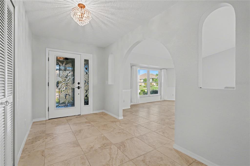 1119 Vía Formia Punta Gorda, FL 33950 - Photo 17 of 58 an empty room with windows and chandelier