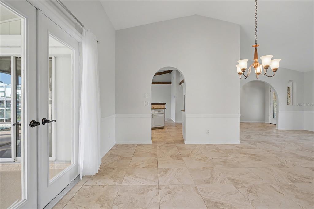 1119 Vía Formia Punta Gorda, FL 33950 - Photo 25 of 58 a view of a hallway with wooden floor and a chandelier