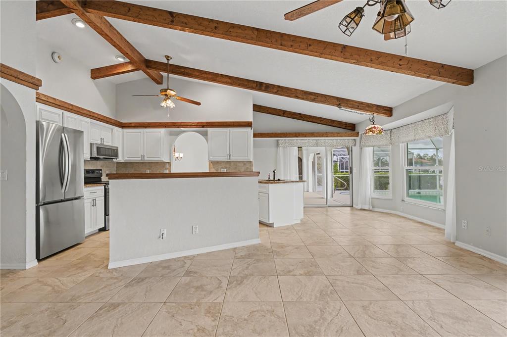 1119 Vía Formia Punta Gorda, FL 33950 - Photo 34 of 58 a kitchen with granite countertop a refrigerator and white cabinets