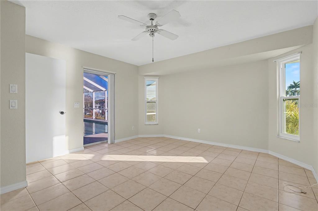 1119 Vía Formia Punta Gorda, FL 33950 - Photo 43 of 58 an empty room with windows and chandelier fan