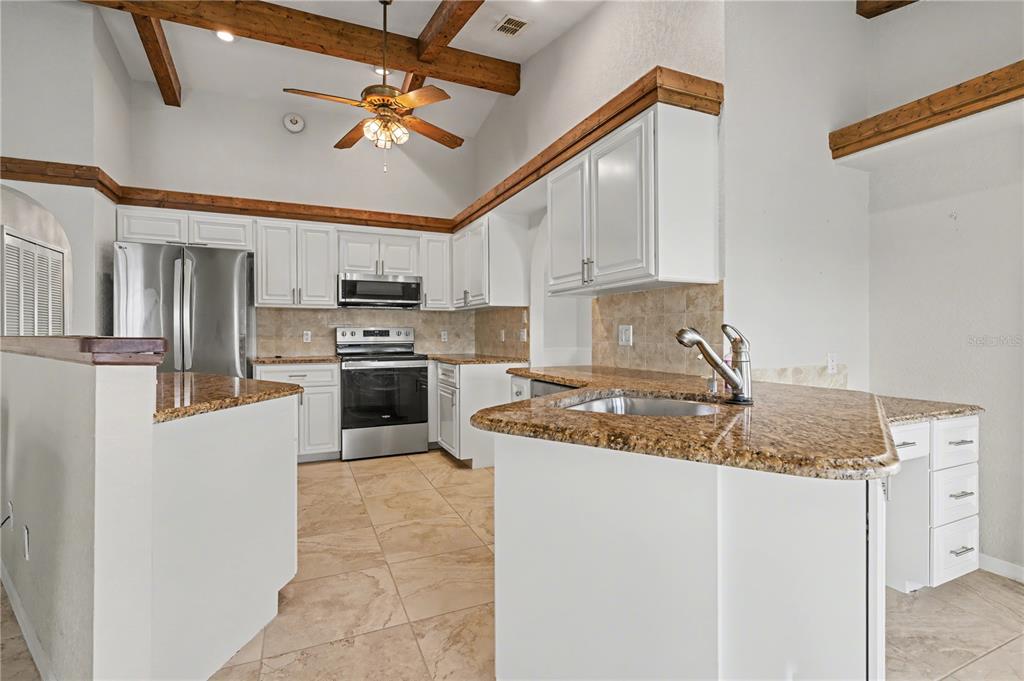 1119 Vía Formia Punta Gorda, FL 33950 - Photo 7 of 58 a kitchen with stainless steel appliances granite countertop a sink stove and refrigerator