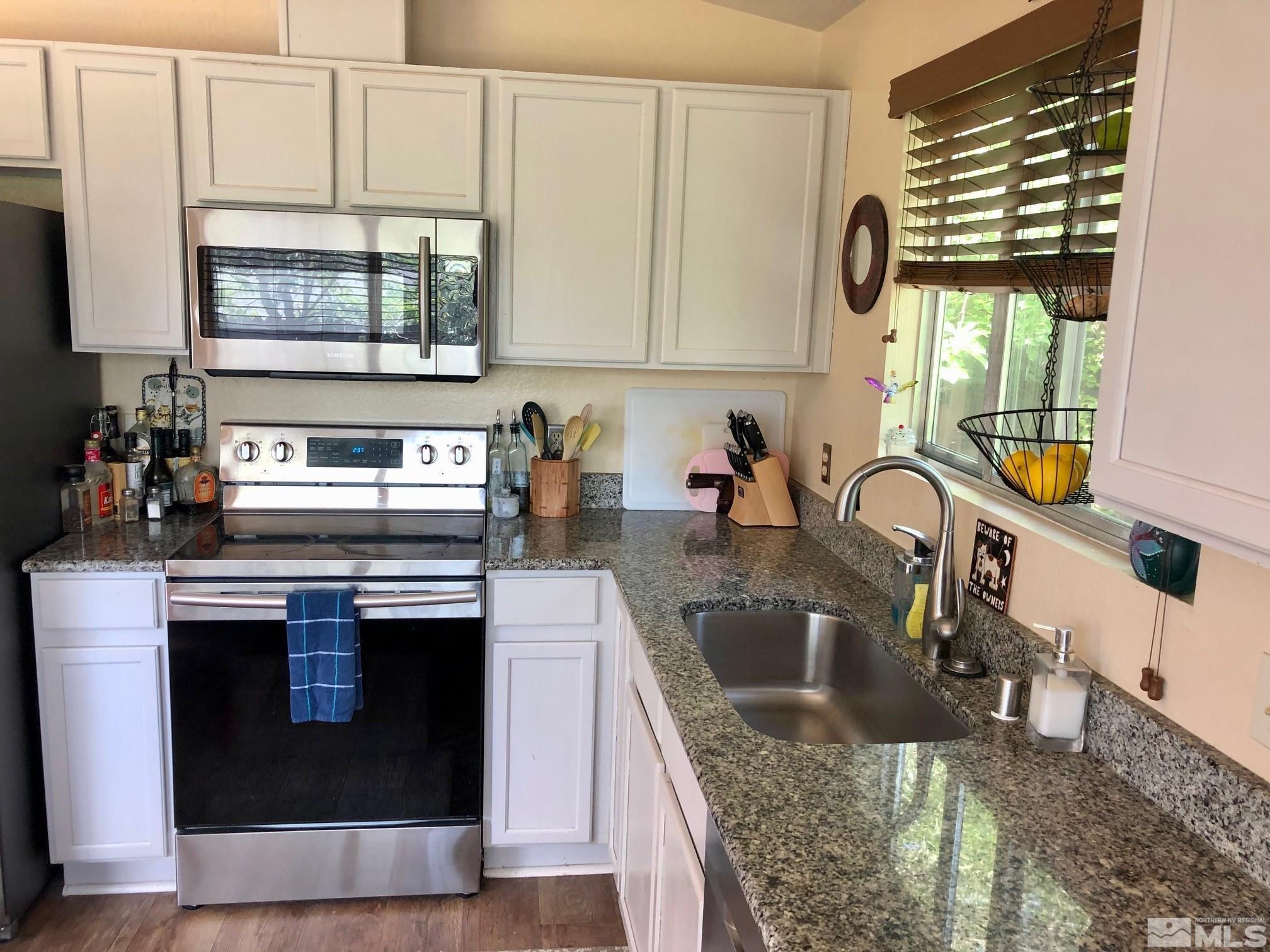 1401 Sandia Court Reno, NV 89523 - Photo 7 of 13 a kitchen with stainless steel appliances granite countertop a sink stove and cabinets