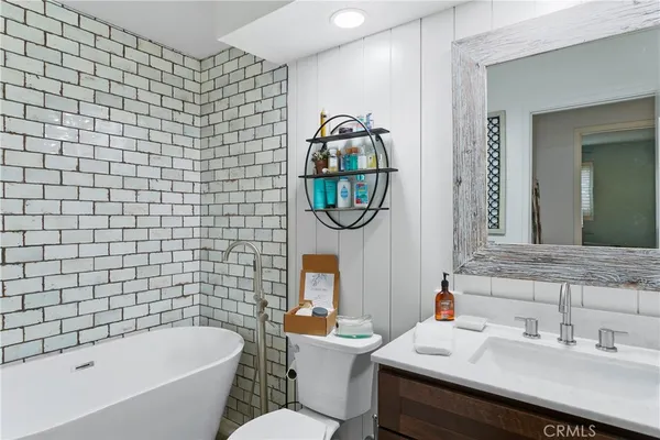 a bathroom with a sink mirror bathtub and toilet