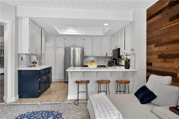 a kitchen with kitchen island granite countertop a sink cabinets and refrigerator