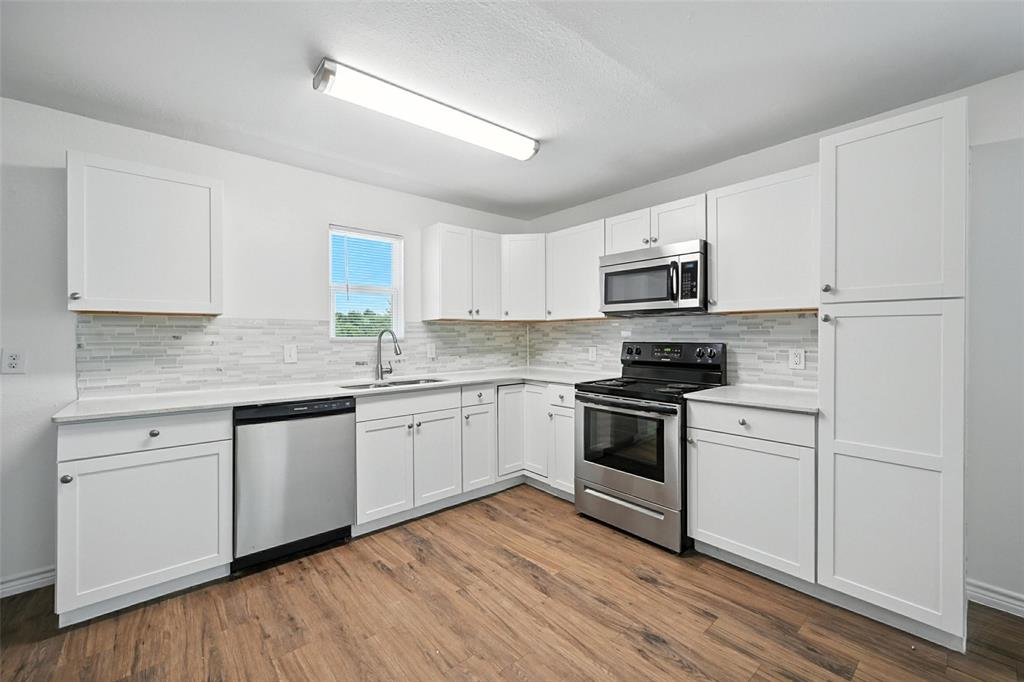 1206 North Business Highway Blue Ridge, TX 75424 - Photo 2 of 37 a kitchen with granite countertop cabinets stainless steel appliances and wooden floor