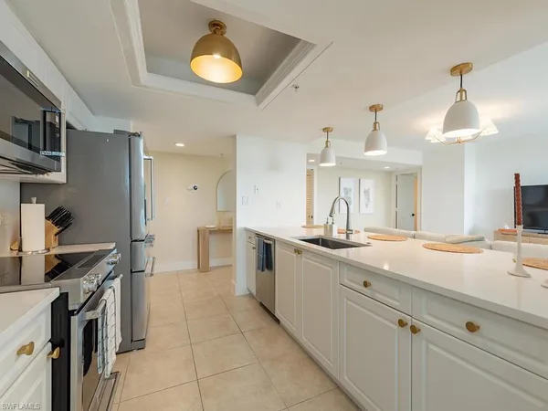a large kitchen with kitchen island a sink stainless steel appliances and cabinets