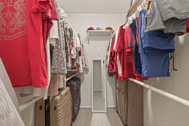 a view of walk in closet with clothes