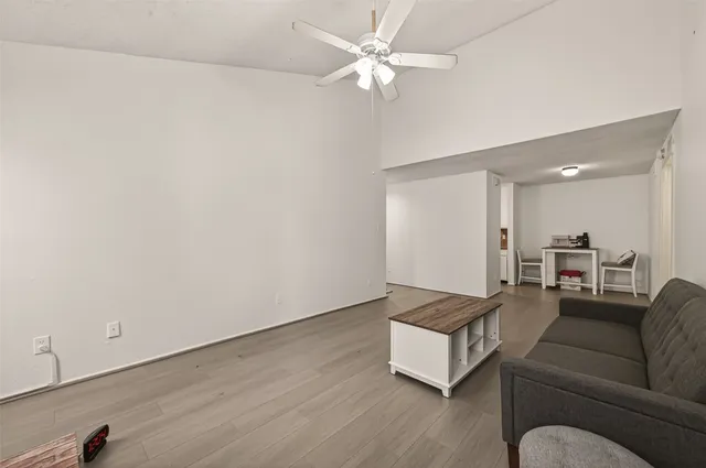 a living room with furniture and a ceiling fan
