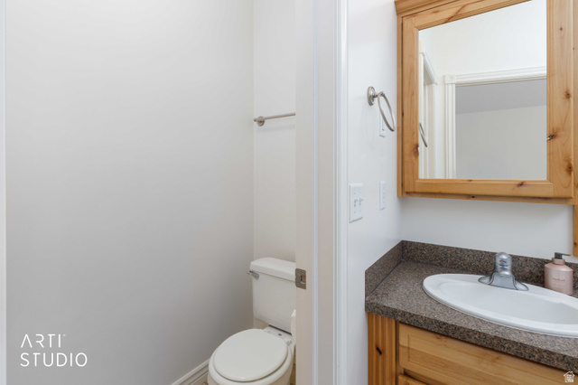 2327 Bluff Ridge Drive Syracuse, UT 84075 - Photo 25 of 66 Bathroom vanity with a wood-finish cabinet, speckled countertop, and integrated sink