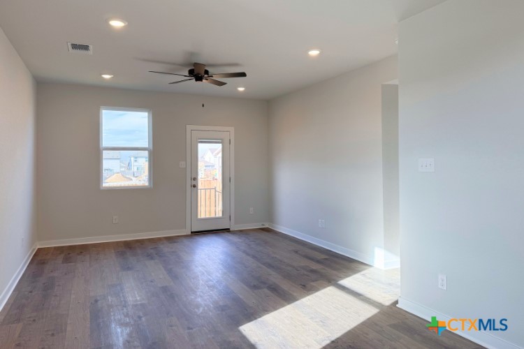 225 Firefox Way Jarrell, TX 76537 - Photo 3 of 11 an empty room with wooden floor and windows