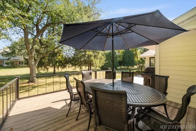 a view of deck with furniture and umbrella