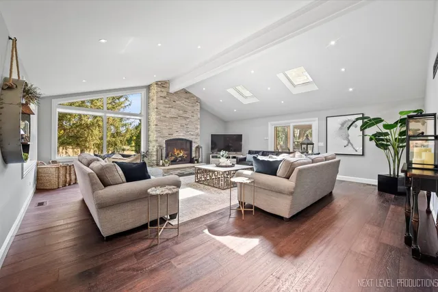 a living room with furniture fireplace and a large window