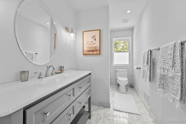 a bathroom with a double vanity sink mirror and toilet