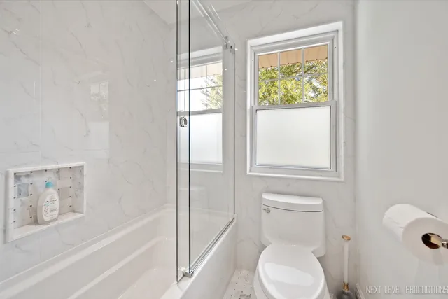 a white toilet sitting next to a bath tub