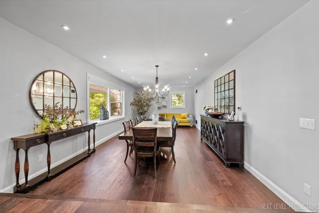 a living room with furniture a chandelier and a wooden floor