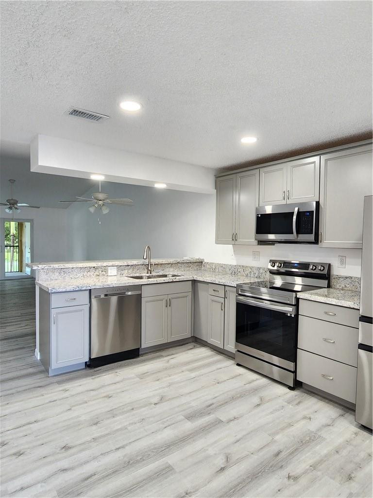 Undisclosed Address Pompano Beach, FL 33063 - Photo 5 of 30 a kitchen with stainless steel appliances granite countertop a stove cabinets and wooden floor