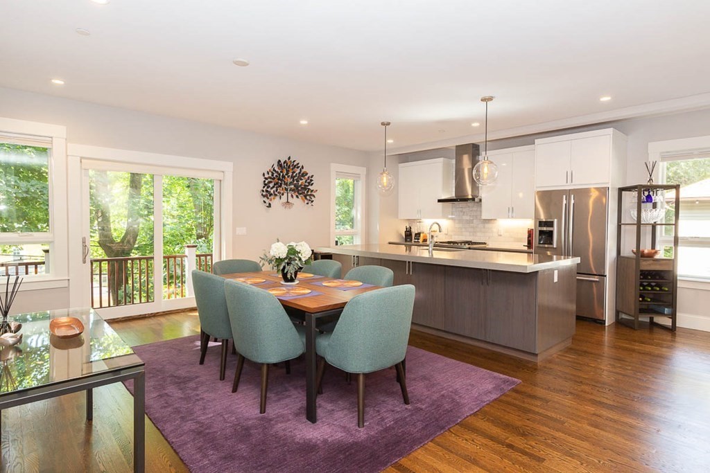 26 Beaconsfield Road, Unit 26 Brookline, MA 02445 - Photo 9 of 35 a kitchen with stainless steel appliances granite countertop a stove a refrigerator a kitchen island a table and chairs