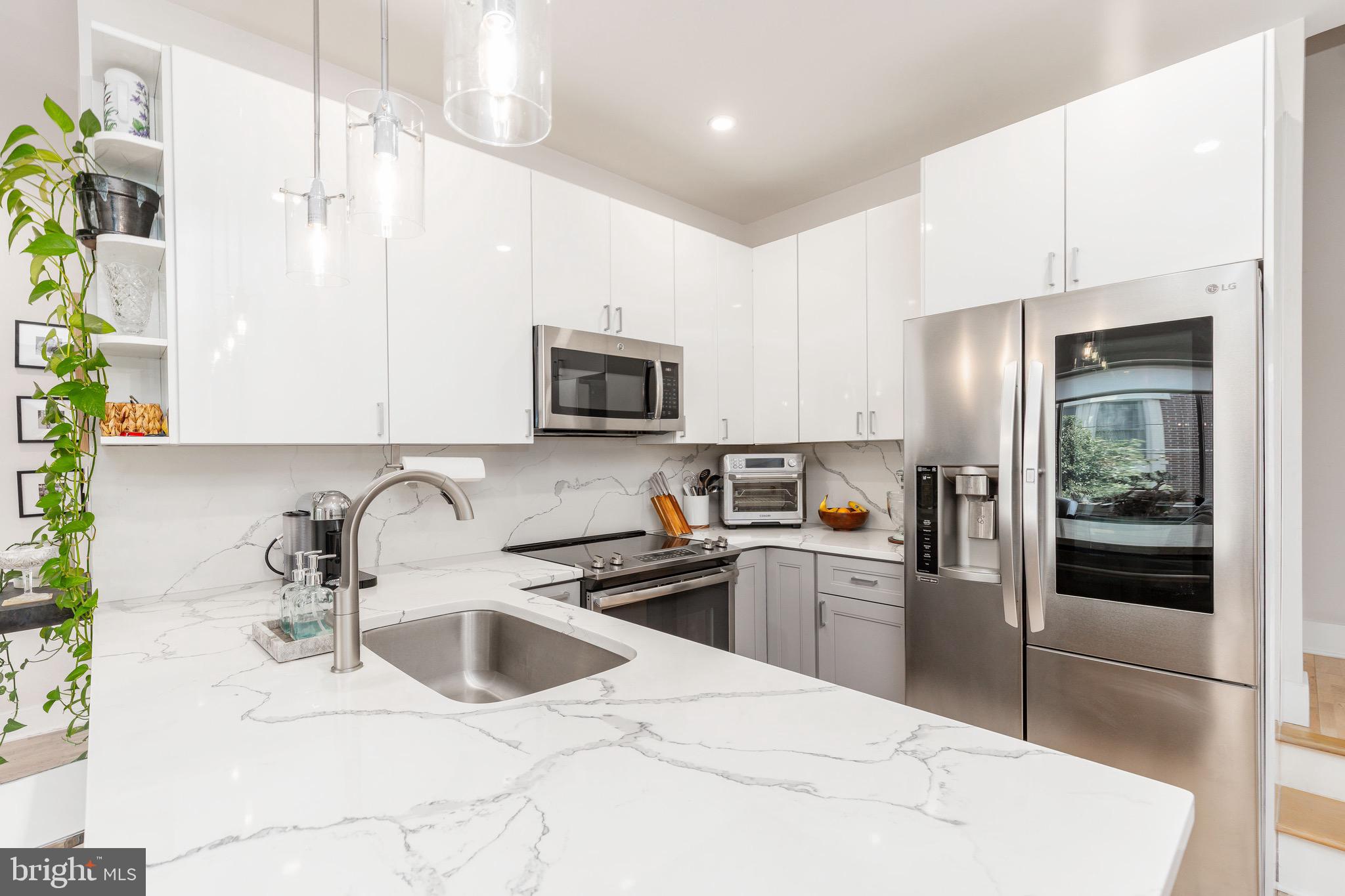 1733 Carpenter Street, Unit D Philadelphia, PA 19146 - Photo 11 of 37 a kitchen with a sink a refrigerator and a stove top oven