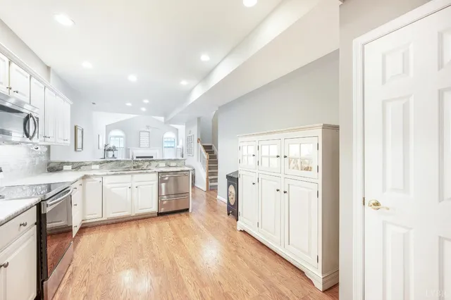 a large kitchen with a lot of counter space and wooden floor