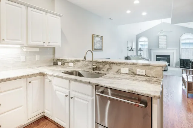a kitchen with granite countertop white cabinets and white appliances