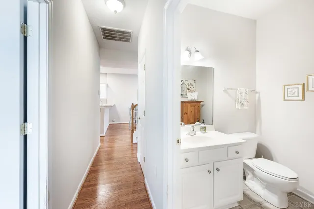 a bedroom with a bed painting on wall and a potted plant