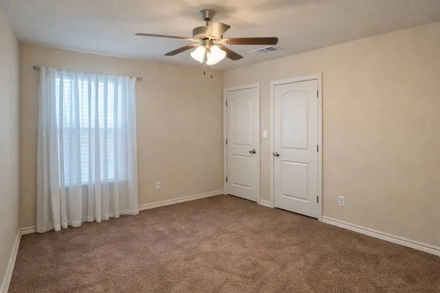 an empty room with chandelier fan
