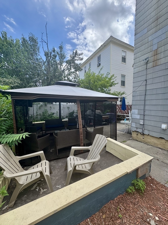 57-59 Walnut Street Lawrence, MA 01841 - Photo 23 of 23 a view of a patio with table and chairs with wooden floor and fence