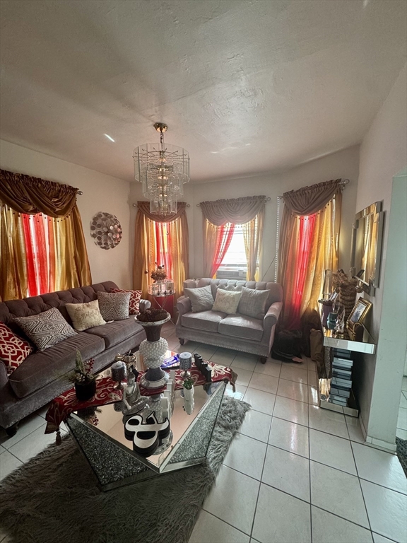 57-59 Walnut Street Lawrence, MA 01841 - Photo 4 of 23 a living room with furniture a fireplace and a chandelier