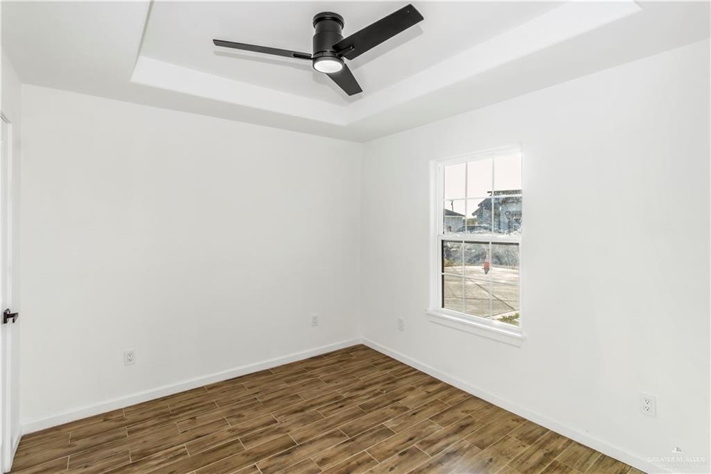 2309 Victoriano Street Weslaco, TX 78596 - Photo 15 of 15 an empty room with wooden floor cabinet and windows