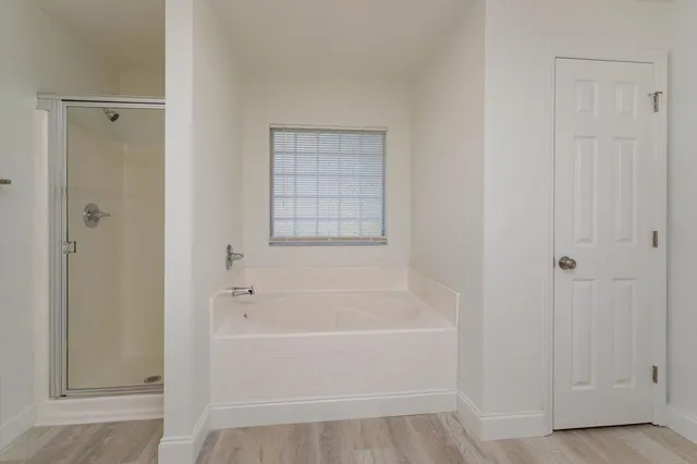 a white bath tub sitting next to a shower