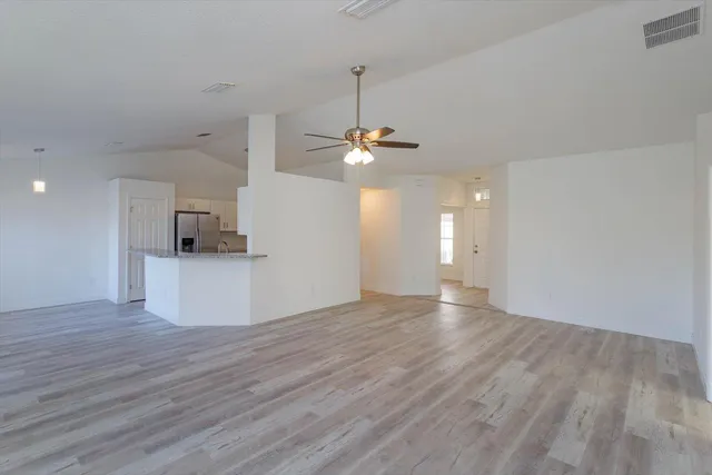a view of a room with wooden floor and a ceiling fan