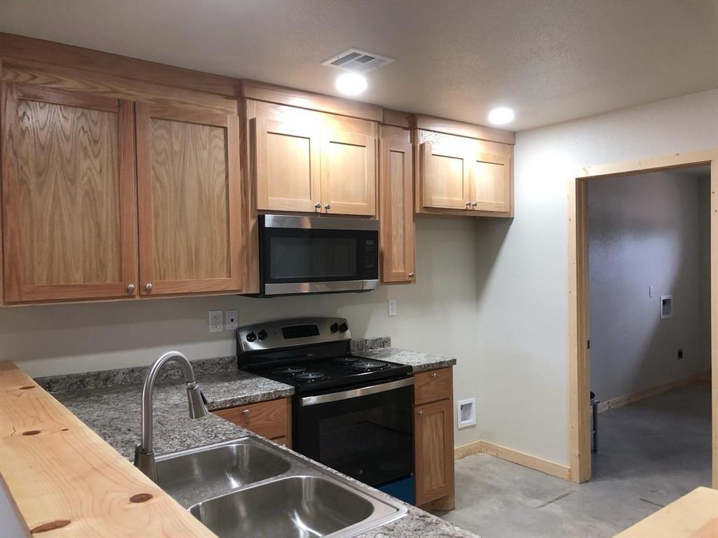 Kitchen featuring baseboards, visible vents, a sink, and appliances with stainless steel finishes