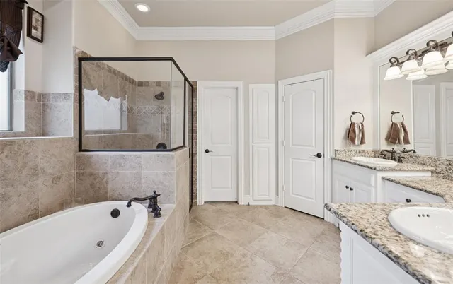 a bathroom with a granite countertop tub sink and mirror