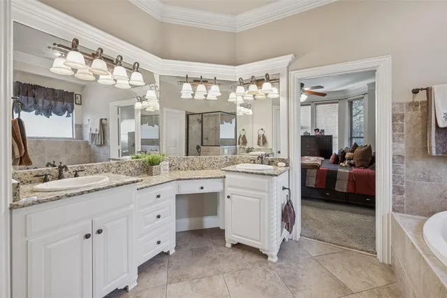 a spacious en suite bathroom with a granite countertop sink mirror and a bathtub
