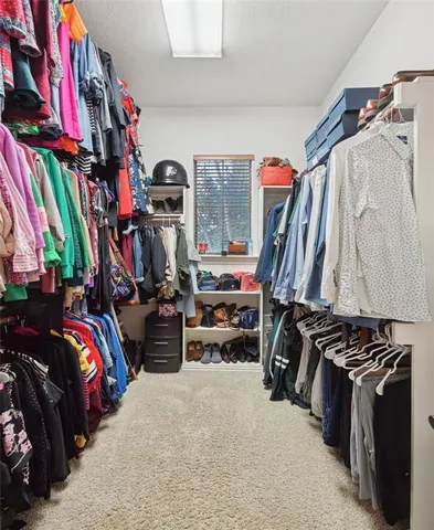 a view of walk in closet with clothes and shoes