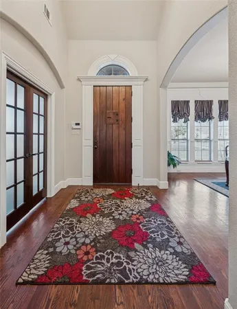 a view of a bedroom with wooden floor and windows