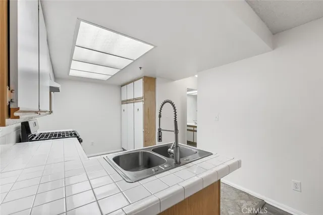 a kitchen with kitchen island a sink and a stove with wooden floor