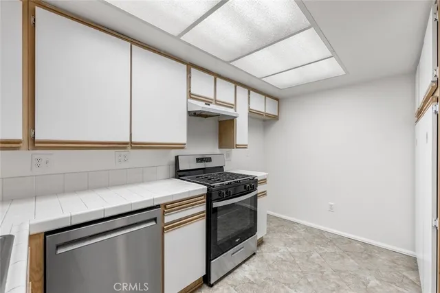 a kitchen with stainless steel appliances granite countertop a sink stove and cabinets