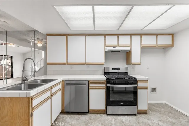 a kitchen with white cabinets and appliances