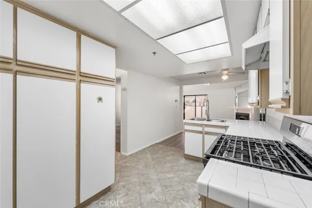 a kitchen with a refrigerator and white cabinets
