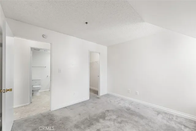 an empty room with white cabinet and a bathroom